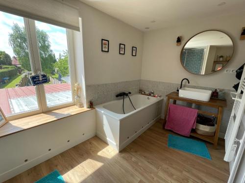 une salle de bain avec une baignoire et un miroir dans l'établissement Chambre chez l habitant avec jardin près de Lille, à Pérenchies