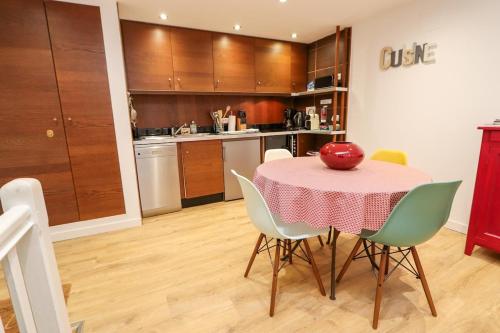 une cuisine avec une table et une pomme rouge. dans l'établissement Le Coq de Landry, à Sarlat-la-Canéda