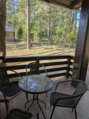 a table and chairs on a porch with a view of a field at Siódma Wyspa in Łupawsko