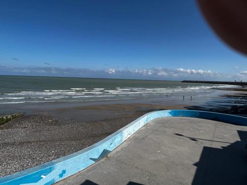 a view of a beach with the ocean at Maison neuves in Biville-sur-Mer