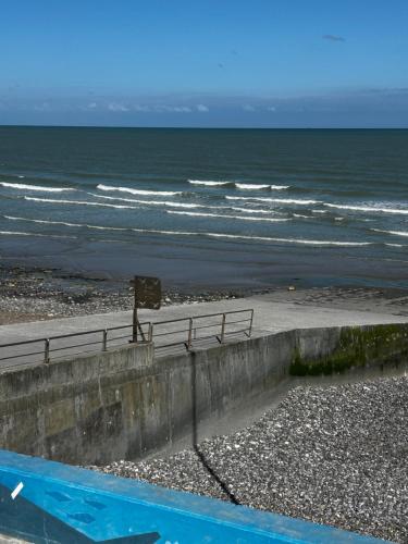 a person standing on the beach near the ocean at Maison neuves in Biville-sur-Mer