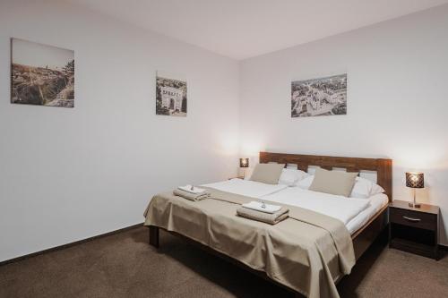 a bedroom with a bed and two pictures on the wall at Residence Malva in Valtice
