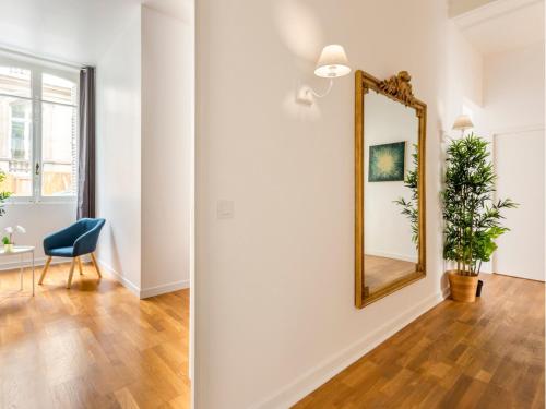 un salon avec un miroir et une chaise dans l'établissement Merveil - Family Suite - Champs Elysees - Monceau, à Paris