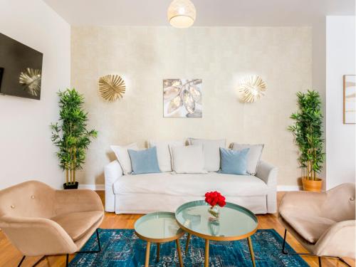 un salon avec un canapé blanc et une table en verre dans l'établissement Merveil - Family Suite - Champs Elysees - Monceau, à Paris