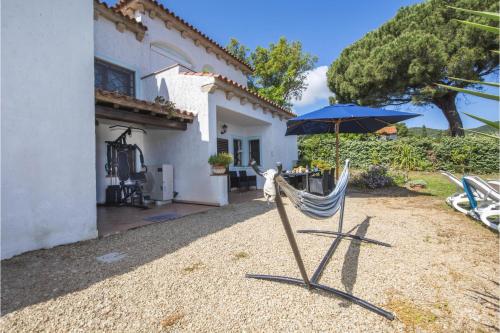 a chair with an umbrella in front of a house at La Sciumara with beach access - Happy Rentals in Cannigione