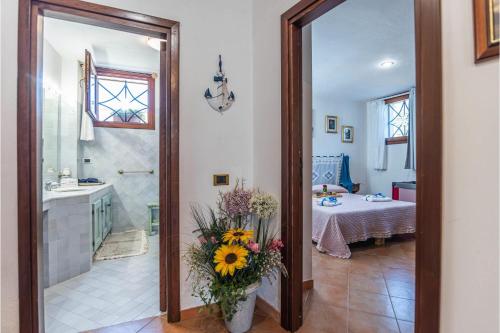 a bathroom with a shower and a sink with a vase of flowers at La Sciumara with beach access - Happy Rentals in Cannigione