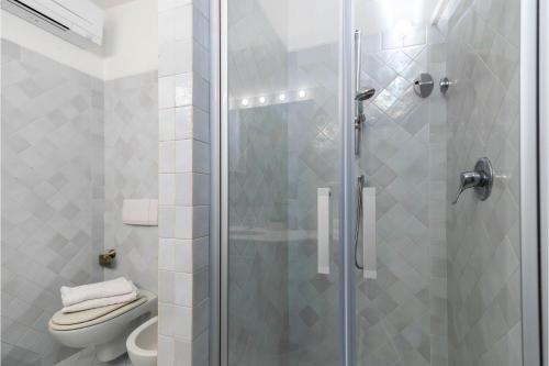 a bathroom with a toilet and a glass shower at La Sciumara with beach access - Happy Rentals in Cannigione