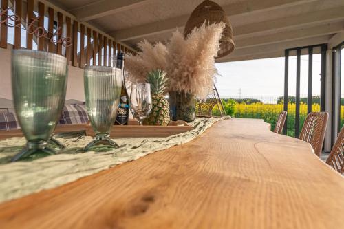 a long wooden table with two wine glasses on it at Lamelove Apartments - Energylandia, Zator in Chocznia