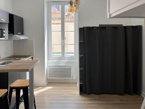 un radiateur noir dans une cuisine avec une fenêtre dans l'établissement Studio tout équipé à deux pas de la plage - 1er étage - 2 personnes, à Les Sables-dʼOlonne