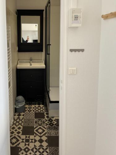 une salle de bain avec un lavabo et un miroir dans l'établissement Studio tout équipé à deux pas de la plage - 1er étage - 2 personnes, à Les Sables-dʼOlonne