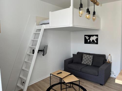 un salon avec un lit mezzanine et un canapé dans l'établissement Studio tout équipé à deux pas de la plage - 1er étage - 2 personnes, à Les Sables-dʼOlonne