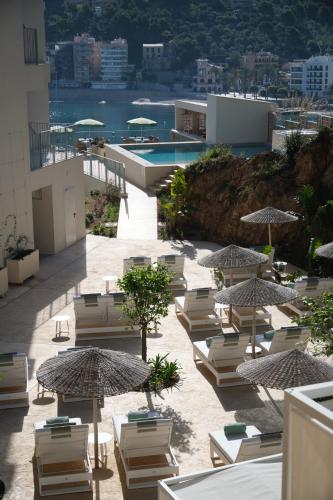 a group of lounge chairs and umbrellas on a building at Salino Port Soller in Port de Soller