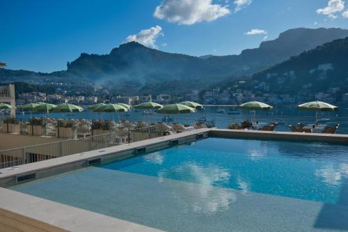 a swimming pool with chairs and umbrellas on a resort at Salino Port Soller in Port de Soller
