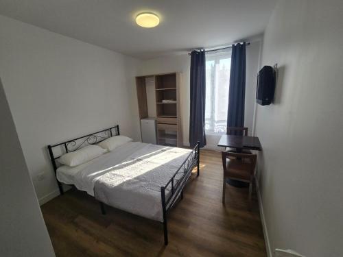 a bedroom with a bed and a television in it at Hôtel de l'Europe in Pantin