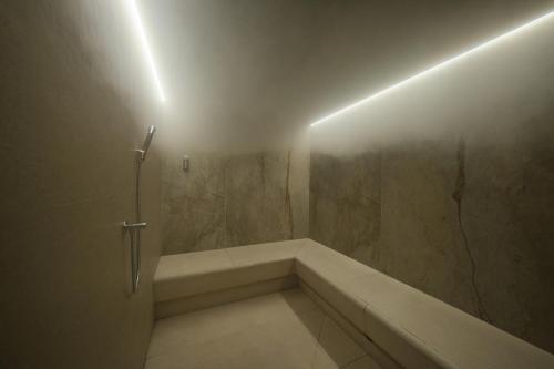 a bathroom with a tub and a shower with a light at Salino Port Soller in Port de Soller