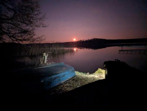 a view of a lake at night with the sunset at Siódma Wyspa in Łupawsko