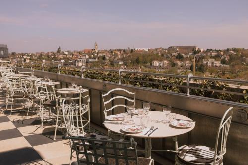 a row of tables and chairs on a balcony at Maison Heler Metz, Curio Collection By Hilton in Metz