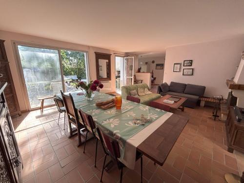 un salon avec une table et un canapé dans l'établissement Villa avec grand terrain entouré de pins idéal pour les amoureux de la nature, à La Tranche-sur-Mer