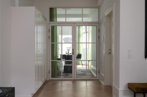 a hallway with sliding glass doors and a dining room at Latin Quarter by Daniel&Jacob's in Copenhagen