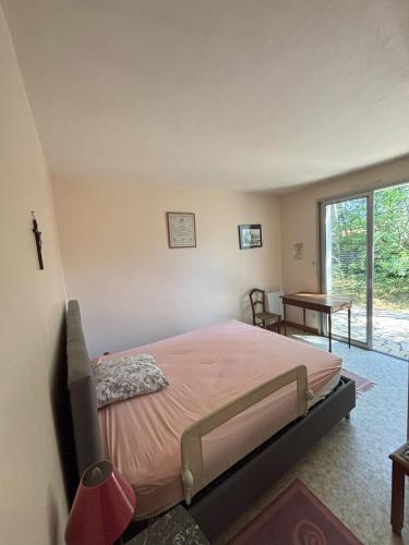 une chambre avec un lit, une table et une fenêtre dans l'établissement Villa avec grand terrain entouré de pins idéal pour les amoureux de la nature, à La Tranche-sur-Mer