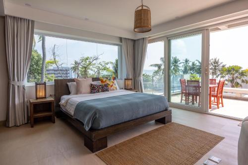a bedroom with a bed and a large window at Selina Serenity Rawai Phuket in Rawai Beach
