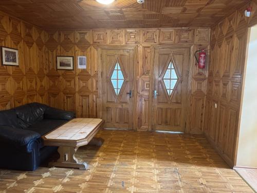 a living room with a couch and a wooden wall at Turnė Guest House in Šiauliai