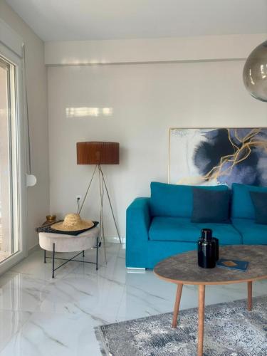 a living room with a blue couch and a table at Cornelia Lux Suites by Horizon Homes in Ofrínion