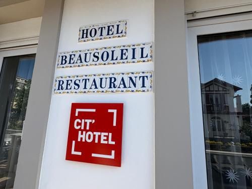 a sign for a hotel on the side of a building at Cit'Hôtel Beausoleil DAX in Dax
