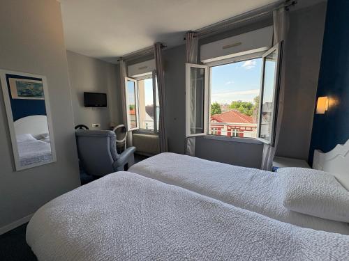 a hotel room with a bed and a window at Cit'Hôtel Beausoleil DAX in Dax