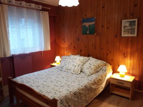 une chambre avec un lit et deux tables de nuit avec lampes dans l'établissement Résidence du Pré Brécel, à Saint-Malo