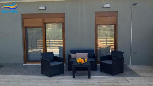 a living room with two chairs and a table with flowers at Litinos Villas in Fodele