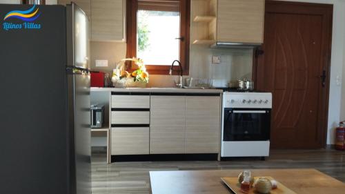 a kitchen with a white stove and a refrigerator at Litinos Villas in Fodele