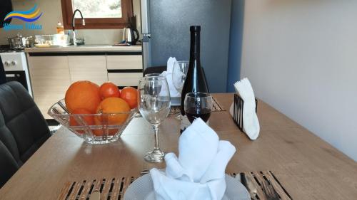 a table with a bowl of oranges and glasses of wine at Litinos Villas in Fodele