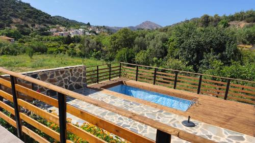 a hot tub on a deck with a fence at Litinos Villas in Fodele