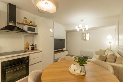 - une cuisine et un salon avec une table en bois dans la chambre dans l'établissement Le Lusso - L'élégance au cœur de Bergerac, à Bergerac