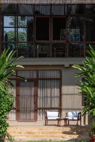 two benches sitting in front of a building at Sanctuary Chitwan National Park in Chitwan