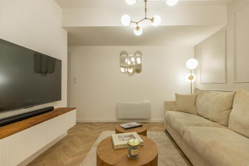 un salon avec un canapé et une télévision dans l'établissement Le Lusso - L'élégance au cœur de Bergerac, à Bergerac