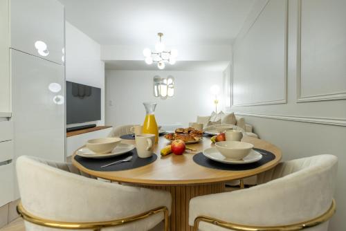 une table de salle à manger avec un bol de nourriture et des chaises dans l'établissement Le Lusso - L'élégance au cœur de Bergerac, à Bergerac