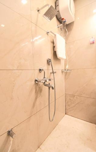 a shower with a glass door in a bathroom at Hotel Sai Swastik in Puri