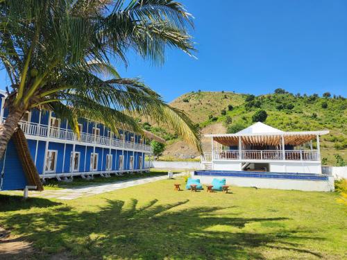 a building with two chairs and a palm tree at Dive dude belongas Lombok Mandalika in Blongas