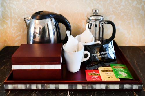 a tray with a coffee maker and a coffee pot on a table at Grand Central Hotel Shanghai - Nanjing Road in Shanghai