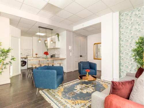 un salon avec des chaises bleues et une table dans l'établissement Merveil - Family Suite - Marais - Sebastopol III, à Paris