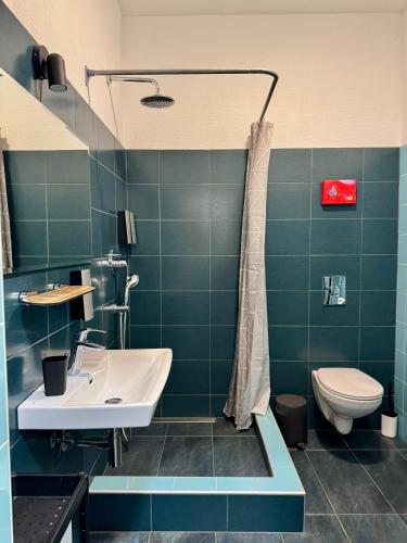 a bathroom with a sink and a toilet at Zeit Hotel in Līgatne