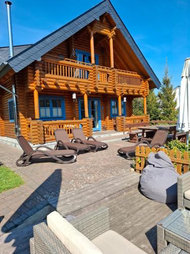 a log cabin with lounge chairs in front of it at Mühlenblick in Medebach