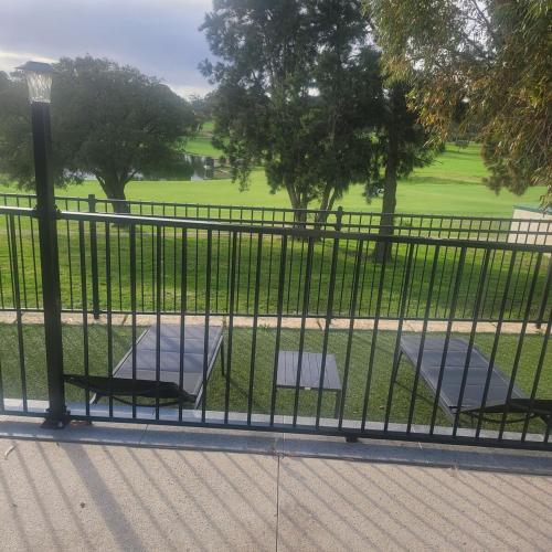 a fence with two chairs in a park at Home away from home in Yanchep