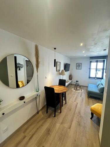- un salon avec une table et un miroir dans l'établissement Mignon Appart Moderne et neuf, à 30min du Lux et pour 4pers, à Bertrange