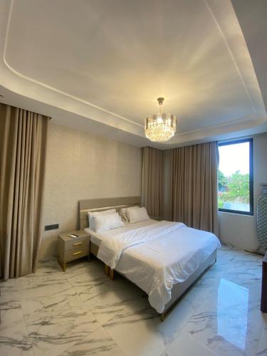 a bedroom with a white bed and a chandelier at Executive One bed - East legon in Accra