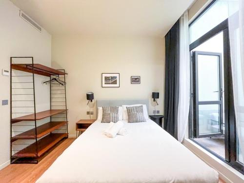 une chambre avec un lit et une grande fenêtre dans l'établissement Urban Flat 139 - Duplex Flat Saint-Germain, à Paris