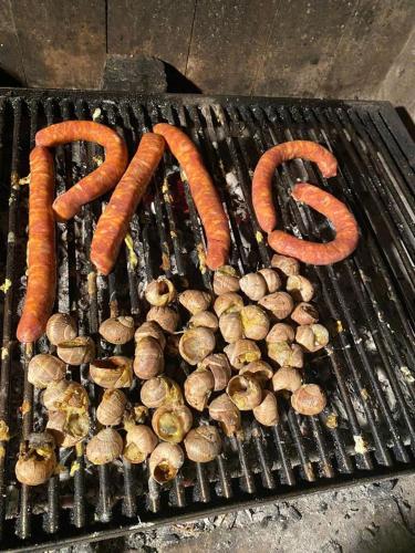 a bunch of sausages and mushrooms on a grill at VillaMar in Pag
