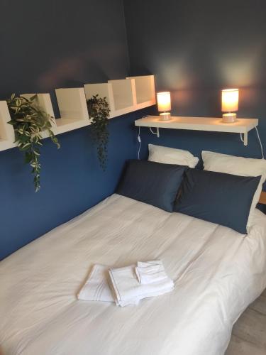 - un lit avec 2 serviettes blanches dans l'établissement Tropicalissime, à Dunkerque